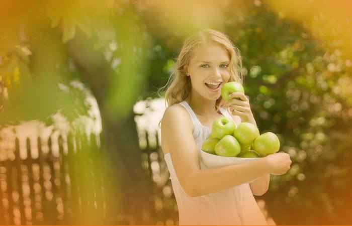 Девушка держит зелёные яблоки
